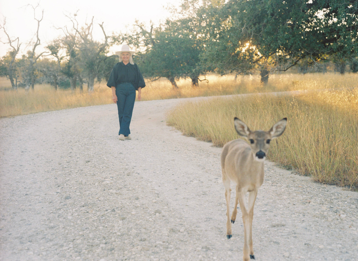 Christy Coleman walking down lane with her deer, Levi.